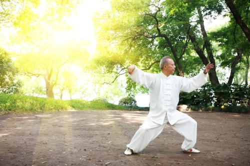 Un homme pratique le tai-chi dans un parc