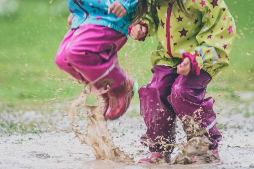 Children jumping into a puddle