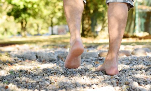 Close-up of feet walking on gravel