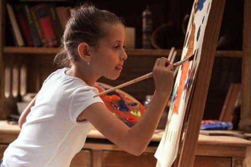 Young girl painting at an easel