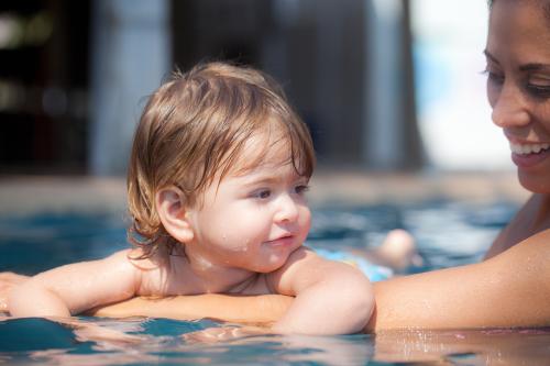 Mother swimming with child