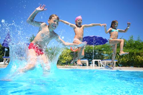 Des enfants sautent du bord de la piscine