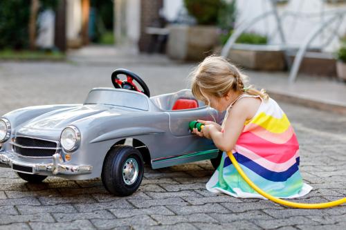 A girl “filling up” her toy car