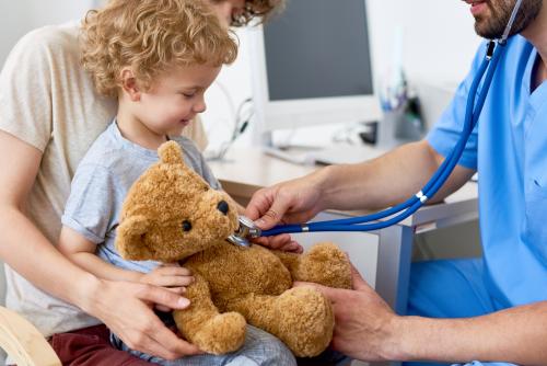 Kind mit Teddy beim Arzt