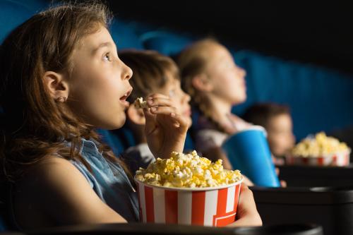 Kinder im Kino mit Popcorn
